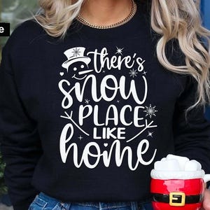 May include: Black sweatshirt with a white snowman graphic and the text "There's snow place like home".