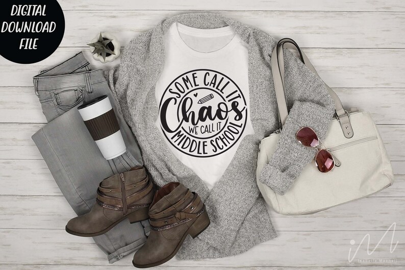 Puede incluir: Camiseta blanca con un dise&ntilde;o circular negro que dice "Some call it Chaos We call it Middle School" con un l&aacute;piz y un coraz&oacute;n gr&aacute;fico.