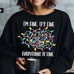 May include: Black sweatshirt with a white graphic of tangled Christmas lights and the text "I'm fine. It's fine. Everything is fine."