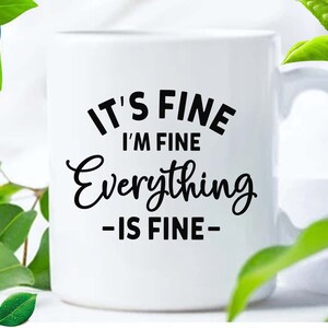May include: A white ceramic mug featuring black text that reads IT'S FINE I'M FINE Everything -IS FINE-. The mug has a standard handle and a smooth cylindrical body. The design is printed in a combination of bold sans-serif and script fonts.