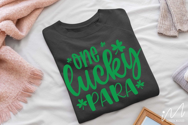 May include: A dark gray sweatshirt with the text "*one lucky PARA*" in green lettering. The text is in a cursive font and includes shamrock symbols.