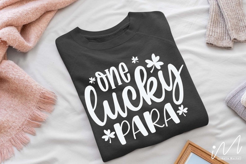 May include: A dark gray sweatshirt with the text "one lucky PARA*" in white lettering. The text is in a cursive font and includes a shamrock graphic.