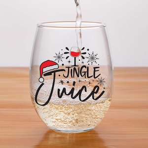 May include: A clear glass wine glass with a red Santa hat and the text "I Jingle Juice" printed on it. The glass is filled with a white liquid and there are snowflakes and stars around the text.