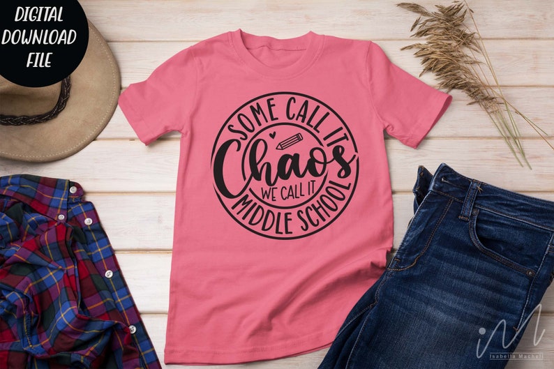 Puede incluir: Camiseta rosa con un dise&ntilde;o circular negro que dice "Some call it chaos we call it middle school" con un l&aacute;piz y un coraz&oacute;n dentro del c&iacute;rculo.