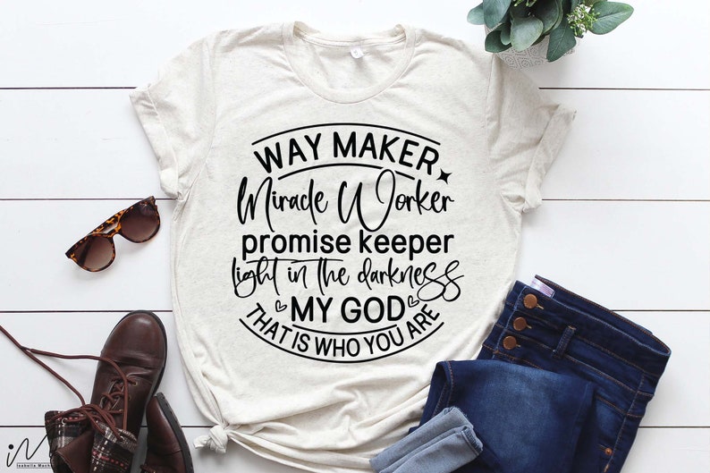 May include: A beige t-shirt with a black circle graphic that says "Way Maker Miracle Worker Promise Keeper Light in the Darkness My God That is Who You Are".