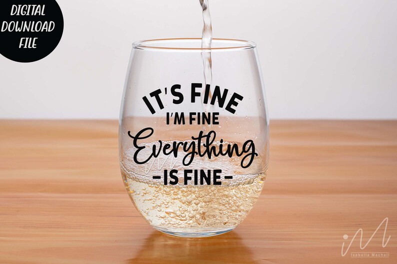 May include: A clear stemless wine glass filled with a pale liquid, featuring the black printed text IT'S FINE I'M FINE Everything IS FINE. The glass has a rounded bowl shape and is being filled with liquid from above, creating small bubbles.