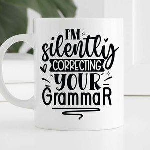 May include: White ceramic mug with a black design that says "I'm silently correcting your grammar".