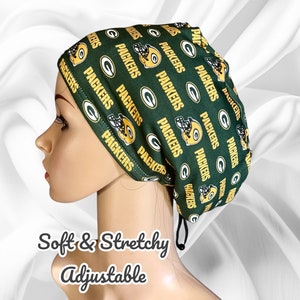 May include: Green and gold adjustable surgical scrub hat with a repeating pattern of the Green Bay Packers logo. The text "PACKERS" is repeated throughout the pattern.  Soft & Stretchy. Adjustable.