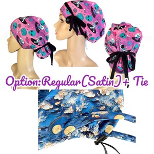 May include: Pink surgical scrub cap with an alien and astronaut print. The cap has a black tie closure and is made of satin. The image also shows a close-up of the blue and white patterned fabric.