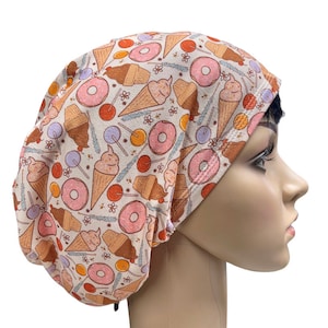 May include: A beige scrub hat with a colorful print of ice cream cones, donuts, and lollipops.