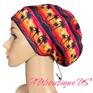 May include: A black scrub hat with a colourful sunset and palm tree print. The hat has a drawstring tie at the back.