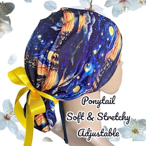 May include: A blue and yellow surgical scrub hat with a starry night print. The hat has a ponytail opening and a yellow ribbon tie. The text "Ponytail Soft & Stretchy Adjustable" is printed on the hat.