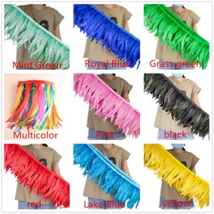 May include: Assortment of feather trim in various colours, including mint green, royal blue, grass green, multicoloured, pink, black, red, lake blue, and yellow. Each trim is shown draped over a person's arm.