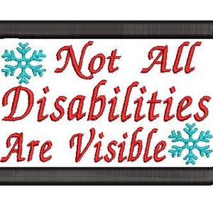 May include: A white rectangular patch with a black border. The text "Not All Disabilities Are Visible" is embroidered in red. Two blue snowflake designs are embroidered on either side of the text.