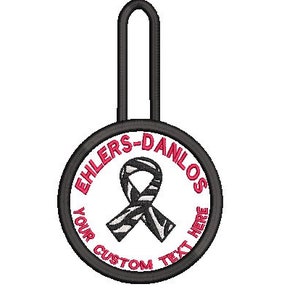 Peut inclure: Un ruban noir et blanc à motif zèbre avec un contour rose, à l'intérieur d'un cercle noir avec le texte "EHLERS-DANLOS YOUR CUSTOM TEXT HERE" en rose.