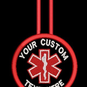 May include: Red and white embroidered medical symbol with a loop for hanging. The text "YOUR CUSTOM TEXT HERE" is embroidered around the symbol.