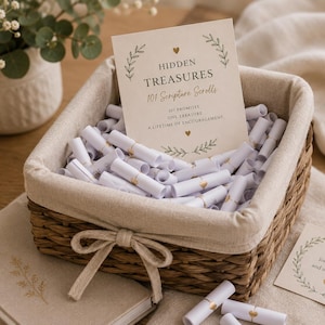 May include: A woven wicker basket with a beige fabric liner filled with small white paper scrolls. A card inside reads: HIDDEN TREASURES 101 Scripture Scrolls, 101 Promises, One Treasure, A Lifetime of Encouragement. A small card nearby reads: You are loved, chosen and never alone.