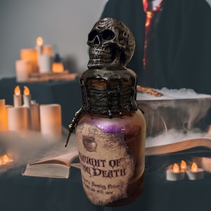 May include: A decorative apothecary bottle with a skull-shaped stopper. The bottle has a label that reads "Draught of Dying Death" and "Powerful Sleeping Potion". The bottle is brown with purple accents and black dripping wax.