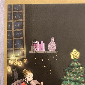 May include: A woman in red pajamas with white stars sits in a chair reading a book titled 'Boo.' The woman has blonde hair in a bun and is wearing a necklace with a small pendant. A cat sits in a chair behind the woman. A Christmas tree with green and red ornaments is in the background. The room is decorated with string lights and a shelf with a vase and books. The room is dark with a window showing a night sky with stars.