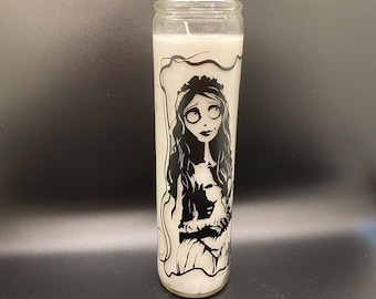 May include: A white candle with a black and white image of a woman with long hair and a dress. The woman is looking to the right of the image.