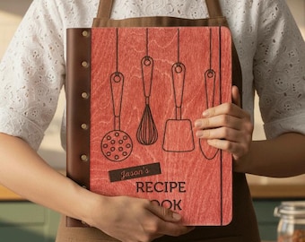 May include: A personalized recipe book with a red wooden cover and brown leather binding. The cover features black line drawings of kitchen utensils. The text "Jason's RECIPE BOOK" is visible on the front.