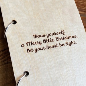 May include: A wooden journal with a ring binding and the text "Have yourself a Merry little Christmas, let your heart be light." engraved on the cover.