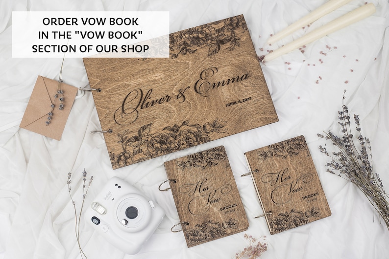 K&ouml;nnte beinhalten: Zwei h&ouml;lzerne Gel&uuml;bdeb&uuml;cher mit Blumendesigns und dem Text "His Vow" und "Her Vow" auf den Deckeln. Ein gr&ouml;&szlig;eres h&ouml;lzernes Gel&uuml;bdebuch mit dem Text "Oliver & Emma" und einem Blumendesign auf dem Deckel.