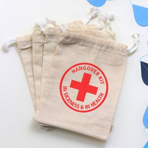 May include: Set of six small, natural-colored fabric drawstring bags with a red circle and white cross graphic. The circle has the text "Hangover Kit In Sickness & In Health".