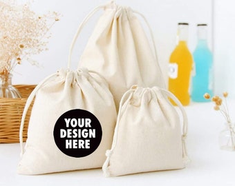 May include: Three white cotton drawstring bags, one with a black circle that says "YOUR DESIGN HERE".