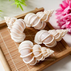 May include: A set of three ceramic vases in varying heights. The vases are white with a textured, ribbed design. The tallest vase is approximately 10 inches tall, the medium vase is 8 inches, and the smallest is 6 inches.