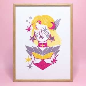 Può includere: Stampa artistica incorniciata con un'illustrazione stilizzata di una figura celeste. L'opera d'arte raffigura una donna con capelli gialli, orecchini a forma di stella e un abito rosa e giallo. Lo sfondo è rosa tenue.