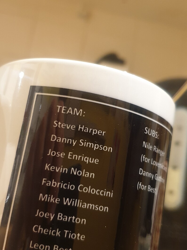 K&ouml;nnte beinhalten: Eine schwarz-wei&szlig;e Tasse mit einer Namensliste. Der Text lautet "TEAM: Steve Harper, Danny Simpson, Jose Enrique, Kevin Nolan, Fabricio Coloccini, Mike Williamson, Joey Barton, Cheick Tiote, Leon Best" und "SUBS: Nile Ranger (f&uuml;r Lovenkrands), Danny Guthrie (f&uuml;r Best)"