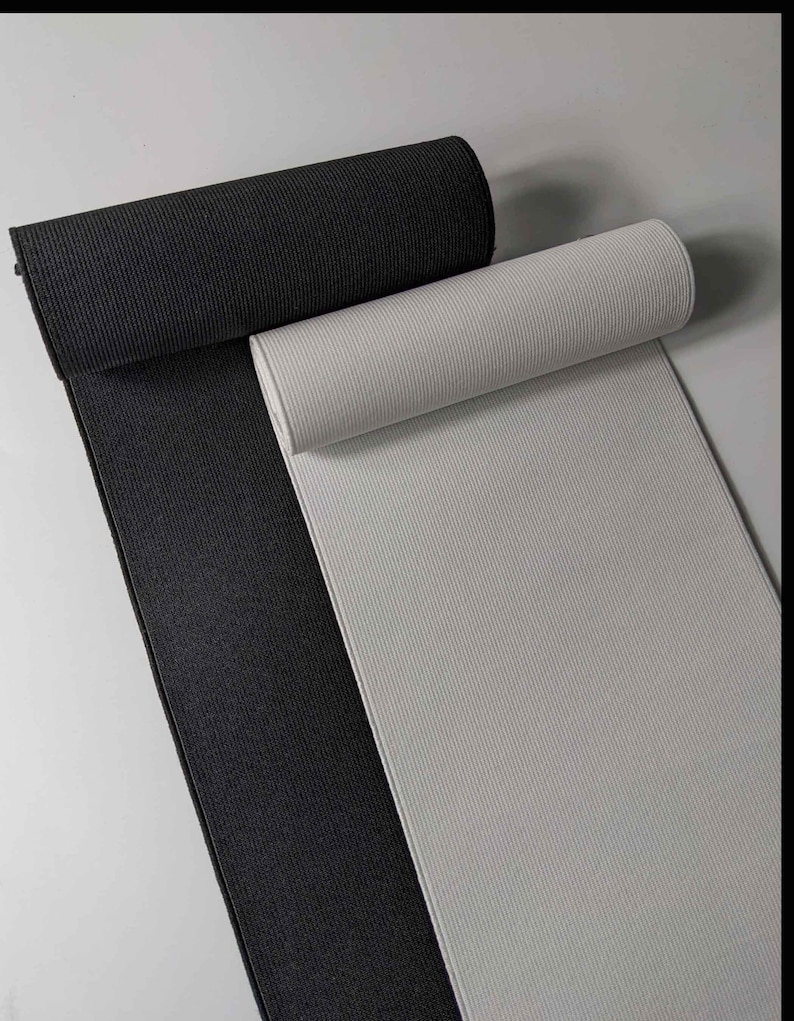 Peut inclure: Deux rouleaux de tissu &eacute;lastique, un noir et un blanc. Le tissu est c&ocirc;tel&eacute; et a une texture extensible.