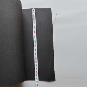 Puede incluir: Un material negro enrollado con una superficie texturizada se mide con una regla. La regla muestra medidas en centímetros. El material parece ser una sustancia similar a la espuma o al caucho.