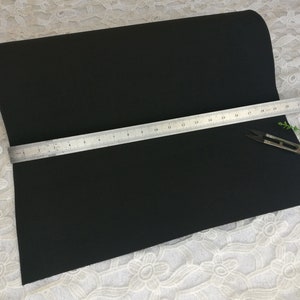 Puede incluir: Una lámina de espuma artesanal negra que mide 61 cm de largo, con una regla y unas tijeras encima.