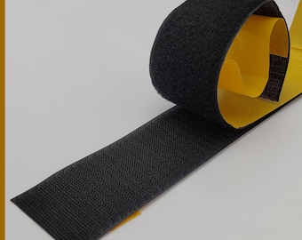 May include: Black hook and loop tape with adhesive backing. The tape is rolled up and the adhesive side is visible.