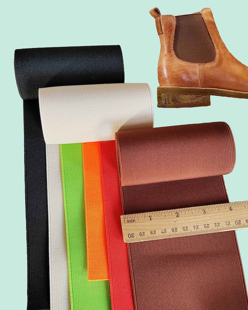 Peut inclure: Cinq rouleaux de tissu &eacute;lastique en noir, blanc, vert, orange et marron. Le tissu est c&ocirc;tel&eacute; et a un l&eacute;ger brillant. Une r&egrave;gle est plac&eacute;e sur le tissu marron, montrant des mesures en pouces.