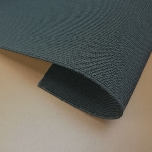 May include: Black elastic fabric with a textured weave. The fabric is folded and rolled, showing the texture and flexibility.