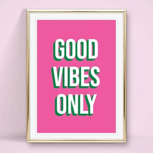 May include: A framed pink poster with the text "GOOD VIBES ONLY" in white letters with a green outline.