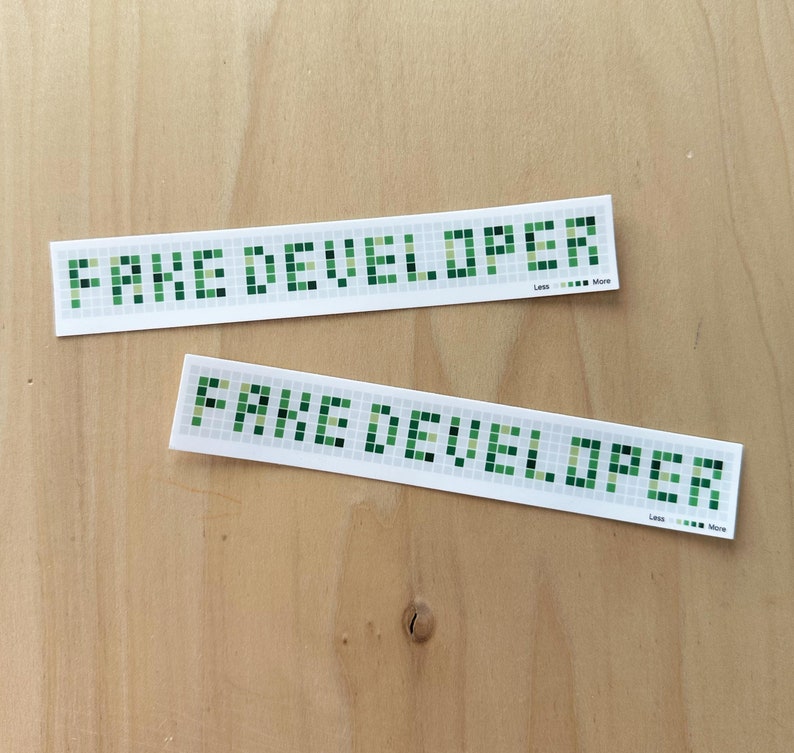 Two vinyl stickers 6" x 1" with white background. They mimic the gray and green squares of the GitHub contribution graph. The green squares spell out the phrase "Fake Developer"