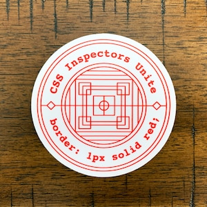 Könnte beinhalten: Ein runder weißer Aufkleber mit rotem Text und Design. Der Text lautet "CSS Inspectors Unite" am Rand, mit "border: 1px solid red;" unten. Das Zentrum zeigt ein geometrisches Design.