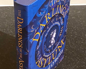 Darlings of the asylum, libro de tapa dura firmado por Noel O Reilly de una edición limitada numerada y firmada de 1300, de los cuales este es el número 1148.