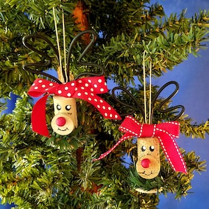 Handmade Wine Cork Reindeer Rudolph Christmas Ornament. These happy little reindeer ornaments are made from wine corks. They have either red polka dot or red with white trim bows and black wire antlers. Each has a red ball nose just like Rudolph.