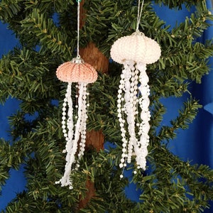 Handmade Sea Urchin Jellyfish Christmas Ornaments. Real sea urchins in varying shades of pink are used to make these lovely jellyfish ornaments. Pearl beads in whites and very pale pink form the tentacles. There is a silver metal top and hanger.