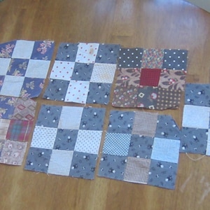 Puede incluir: Una colección de ocho cuadrados de patchwork con varios patrones y colores. Los cuadrados presentan diseños florales, de lunares y a cuadros en tonos de azul, rojo y marrón. Los cuadrados están dispuestos sobre una superficie de madera.