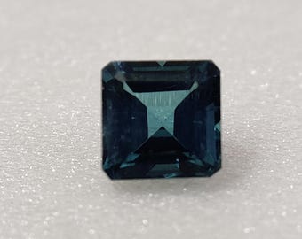Può includere: Una pietra preziosa blu scuro con taglio smeraldo quadrato.