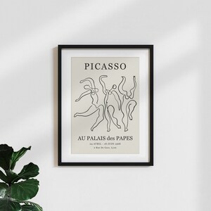 May include: A black and white framed poster with the text "PICASSO" and "AU PALAIS des PAPES" in a minimalist style. The poster features a line drawing of dancing figures.