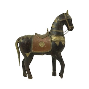 Pode incluir: Uma figura de cavalo de madeira com uma sela e uma rédea de cobre e latão. O cavalo é castanho escuro e tem uma cauda longa.