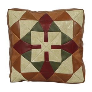 May include: Square decorative pillow with a geometric patchwork design. The pillow features a mix of colors including brown, tan, green, and burgundy. The pillow has a brown border and a square shape.