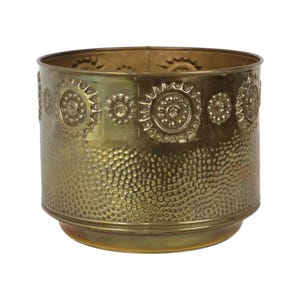 May include: A cylindrical brass planter featuring a polished finish. The upper section is decorated with a repeating embossed sunburst pattern, while the lower portion displays a dense, hammered texture across the entire circumference.
